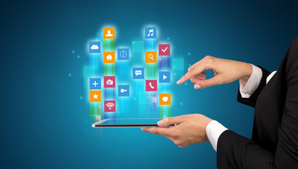 Female elegant hand holding tablet with colourful application icons