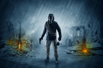 Destroyed place after a catastrophe with man in gas mask and weapon on his hand
