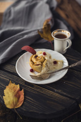 coffee and cinnamon bun on wooden table