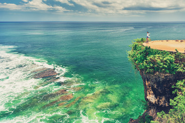 Active LifeStyle Travel and concept: Adult traveler woman standing on top mountain cliff and enjoy amazing nature landscape tropical beach Bali