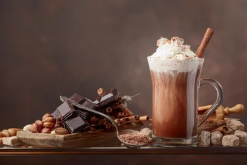 Fotobehang Chocolade Warme chocolademelk met room, kaneel, chocoladestukjes en diverse kruiden.