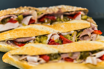 Fresh baguette sandwich on wooden background. Classic BLT sandwiches. Close up.