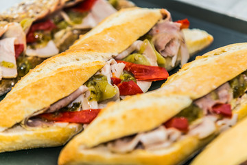 Fresh baguette sandwich on wooden background. Classic BLT sandwiches. Close up.