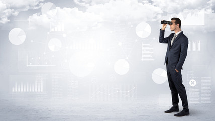 Businessman looking forward with binoculars cloudy background and graphs, charts around
