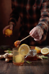 Ginger tea with honey , lemon and mint on old wooden table .