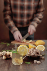 Ginger tea with brown sugar , lemon and mint on old wooden table .