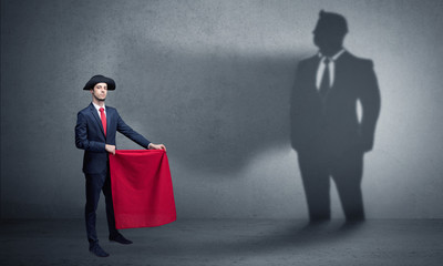 Fototapeta premium Businessman standing with red cloth on his hand and his shadow on the background 