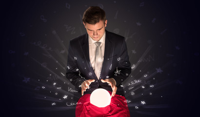 Gorgeous businessman looking to inspiration in a magic ball in his lap and doodle concept
