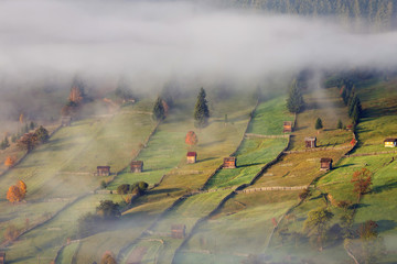Foggy autumn morning above the traditional romanian cottages