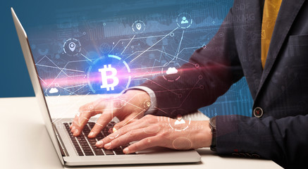 Hand checking on laptop global bitcoin exchange rate concept
