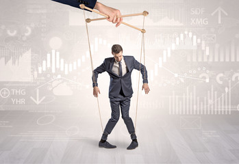 Puppet businessman controlled by another hand with financial concept
