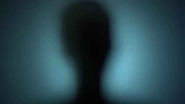 Psychotic man pounding on glass, scary silhouette, ghost from another world. Blood-chilling horror thriller shot