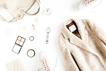 Women fashion clothes and accessories. Flat lay female autumn style look with warm coat, cap, sneakers, on white background. Top view.