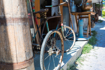 Fototapeta na wymiar Old children's bicycle. An ancient children's tricycle on a street pavement. Sozopol. Bulgaria