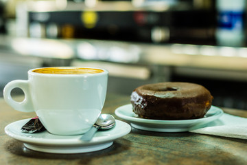 Cup of cofee and xocolate donut.