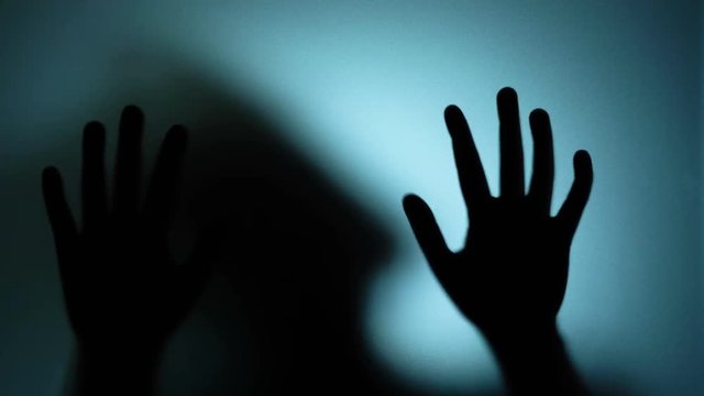 Woman beating furiously on glass, kidnapped victim, crazy person, horror scene. Blood-chilling horror thriller shot