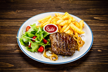 Grilled steak, French fries and vegetables