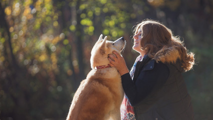 Young woman on a walk with her dog breed Akita inu