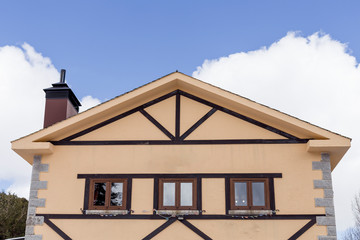 old yellow house in the middle of the mountain, blue and cloudy sky. winter or spring season