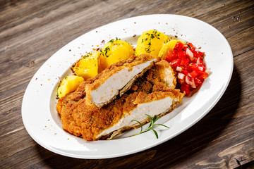 Fried pork chop, boiled potatoes and vegetable salad