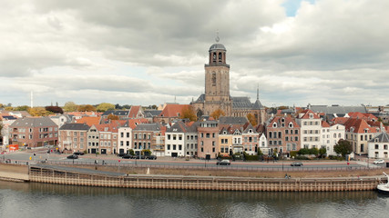 Obraz premium Aerial view of the Dutch medieval city of Deventer in The Netherlands with the principal church and facades of historic homes seen from the other side of the river IJssel that passes it