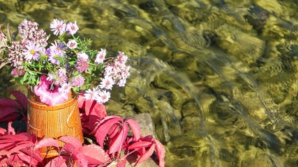 Autumn bouquet in a wicker basket on the background of the river, floristic composition