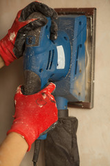 Home improvement plasterer worker working with sander for smoothing wall surface