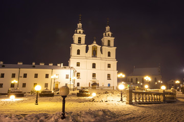 Fototapeta na wymiar Church in Minsk. Holy spirit cathedral in centre of Belarus capital. Famous exterior of building of church. Night Minsk. Minsk in the evening. Night lights and lanterns shining on street.