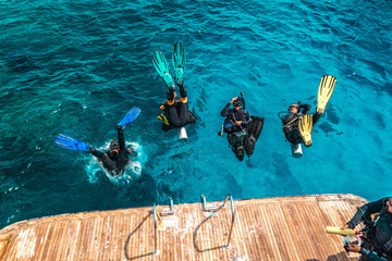 scuba diver sit on the yacht and ready to dive.
