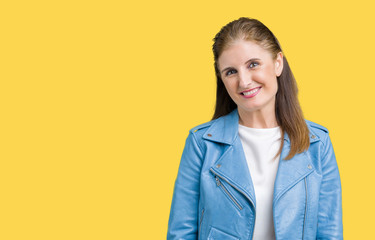 Beautiful middle age mature woman wearing fashion leather jacket over isolated background winking looking at the camera with sexy expression, cheerful and happy face.