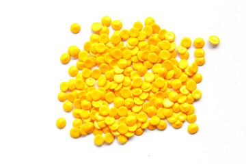 close up of yellow industrial plastic pellet on white background