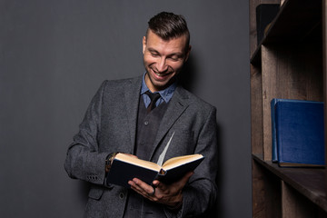 Man in suit reads book