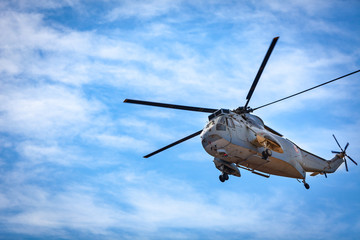 Fototapeta premium Flying Helicpoter with Spinning Propellers and Blue Sky