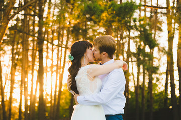 Close-up portrait of a couple of newlyweds standing in the pine forest