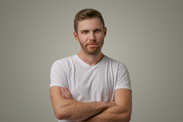 Bearded guy frowning face, dissatisfied with the results of competition, holding hands crossed, requires an explanation of why he loses. Angry surly man with stylish hairstyle isolated on white wall