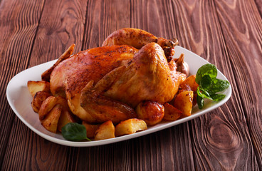 Roast chicken with potatoes on plate