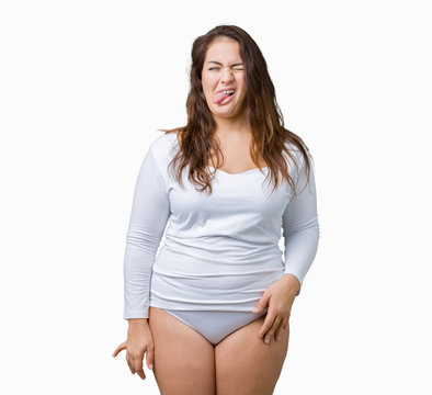 Beautiful plus size young overwight woman wearing white underwear over isolated background sticking tongue out happy with funny expression. Emotion concept.