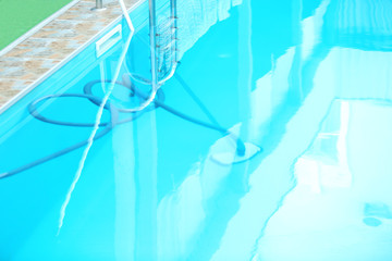Cleaning outdoor pool with underwater vacuum, closeup