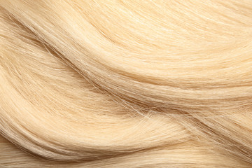 Texture of healthy blond hair as background, closeup