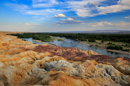Rainbow Beach, Five Colored Hills scenic area, an oasis in the desert near Burqin. Buerjin, Altay, Xinjiang Province, China. Colorful hills and the beautiful Irtysh River. Exotic Asia Landscapes