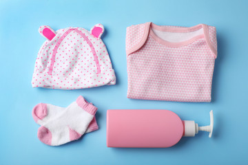 Flat lay composition with stylish baby clothes on color background