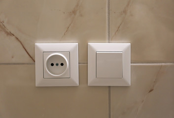 Electric socket and light switch on wall