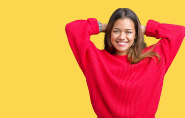 Young beautiful brunette woman wearing red winter sweater over isolated background Relaxing and stretching with arms and hands behind head and neck, smiling happy