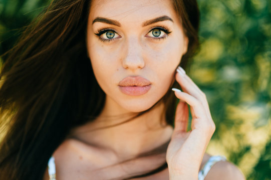 Closeup lifestyle portrait of celebrity female model.  Beautiful girl face on abstract nature background. Cheerful amazing young woman face expression. Sexy blue eyed babe. Glamour youth appearance.