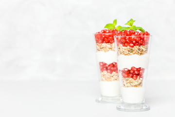 Pomegranate parfait - sweet organic layered dessert with granola flakes, yogurt and ripe fruit seeds.