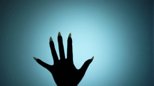 Monster behind the wall, hand with sharp nails silently slipping down, demon. Blood-chilling horror thriller shot