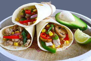 Burritos wraps with beef and vegetables on black background. Beef burrito, mexican food