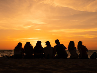 Group of people silhouette on the sunset beach time