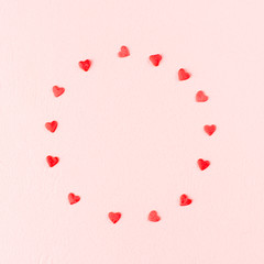 Valentines day love concept. Frame of red hearts on pink background.