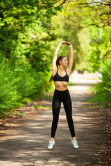 Girl doing sport. Young Female Exercising in a Park